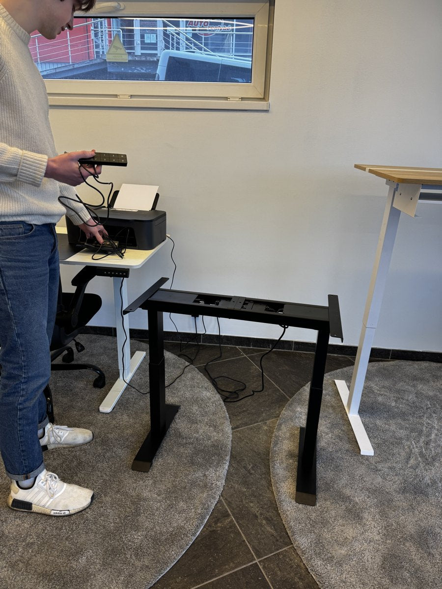 A desk frame and controllers being examined in the Ergonix office