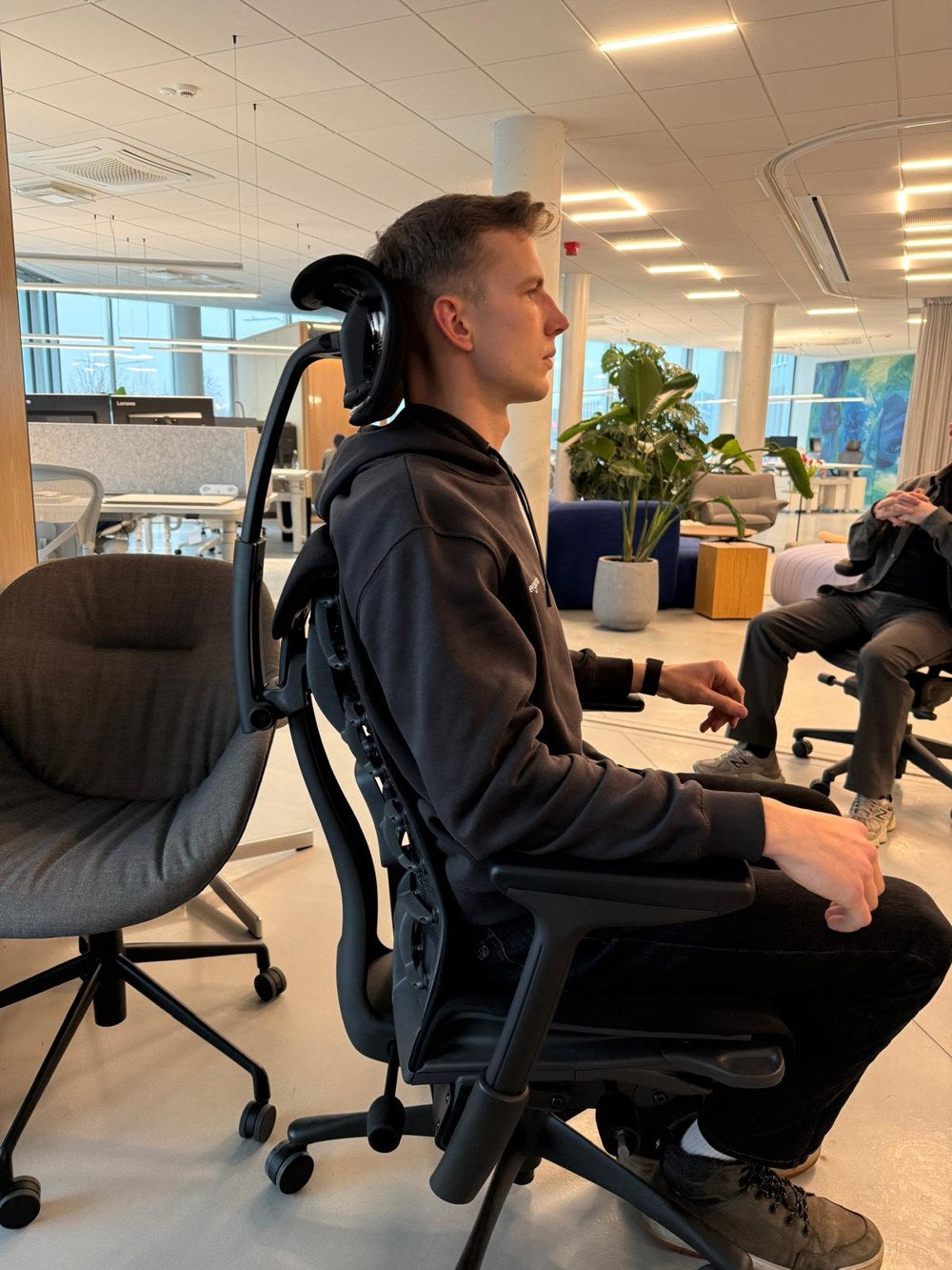 Lukas trying a Herman Miller chair in a showroom
