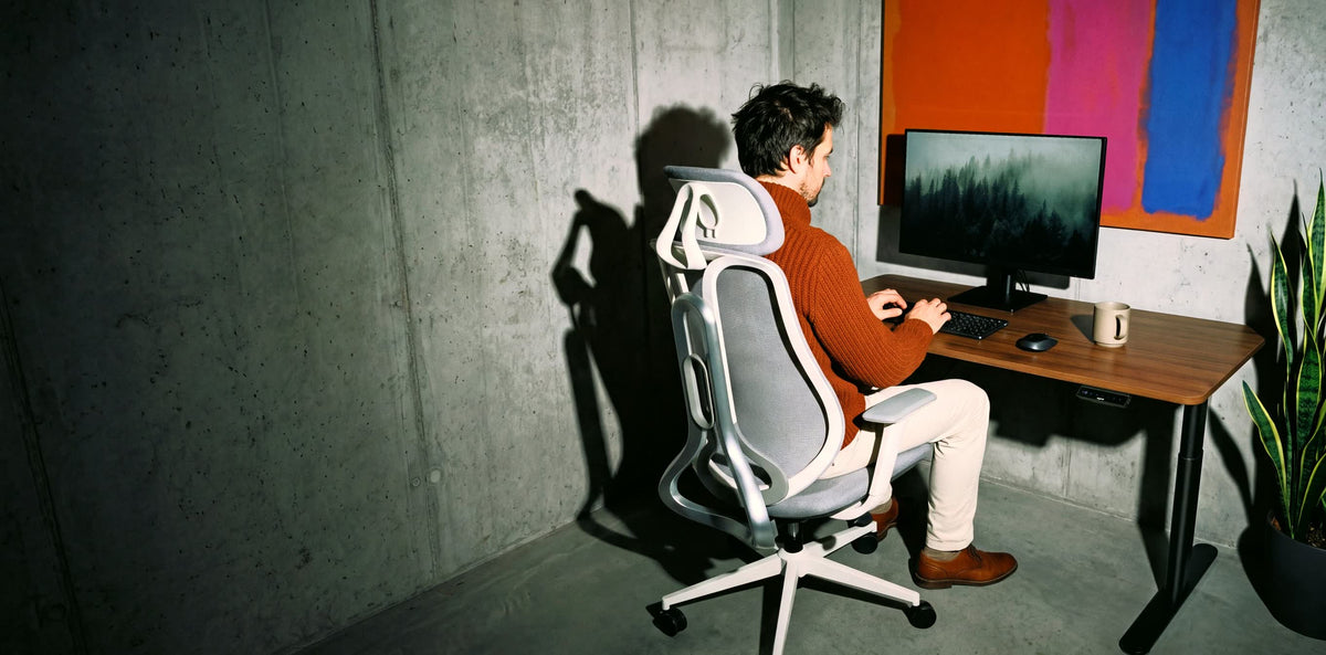 Vyras dirba sėdėdamas OmniSit Pro kėdėje